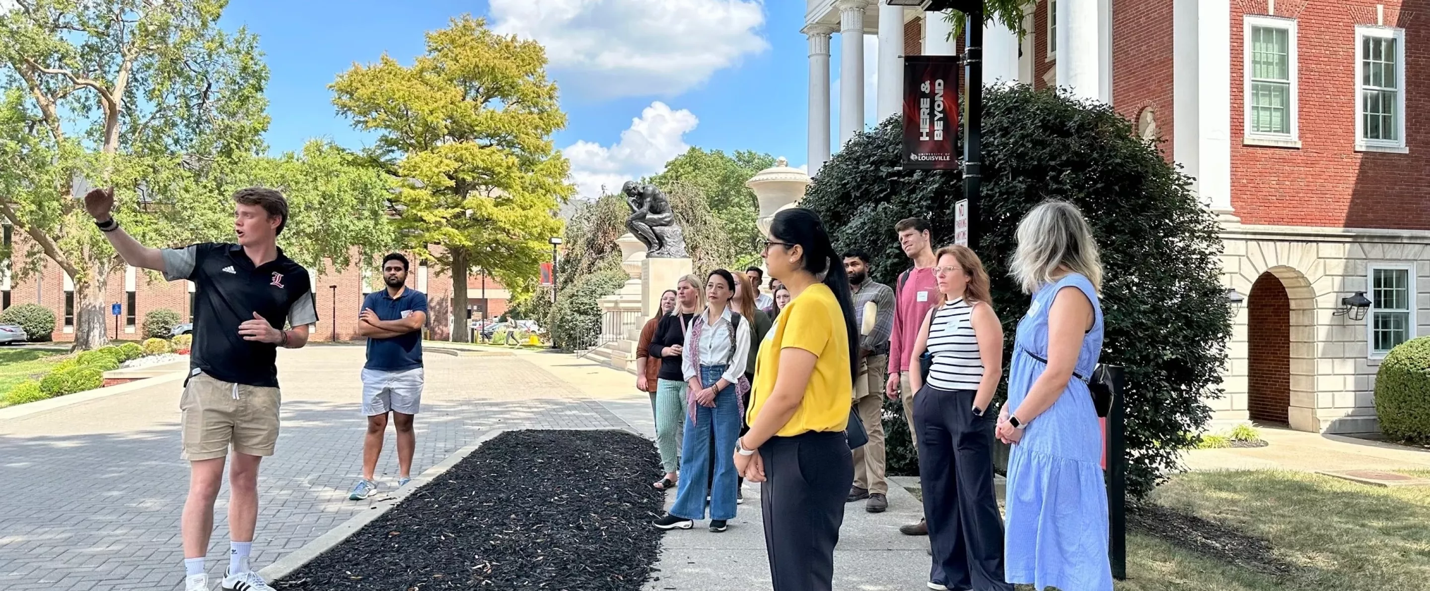 New Employee Orientation group touring Belknap Campus out front of Grawemeyer Hall