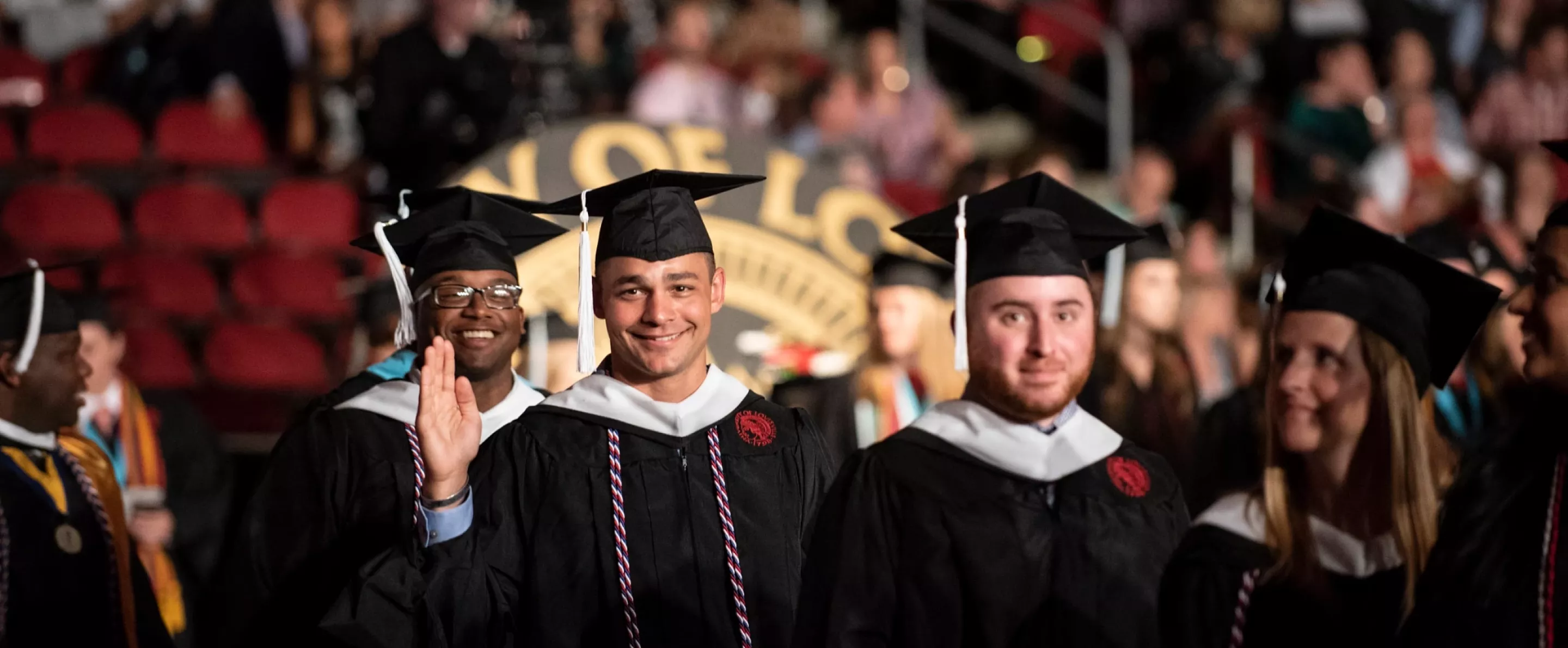 Graduate waves as he lines up to receive his diploma