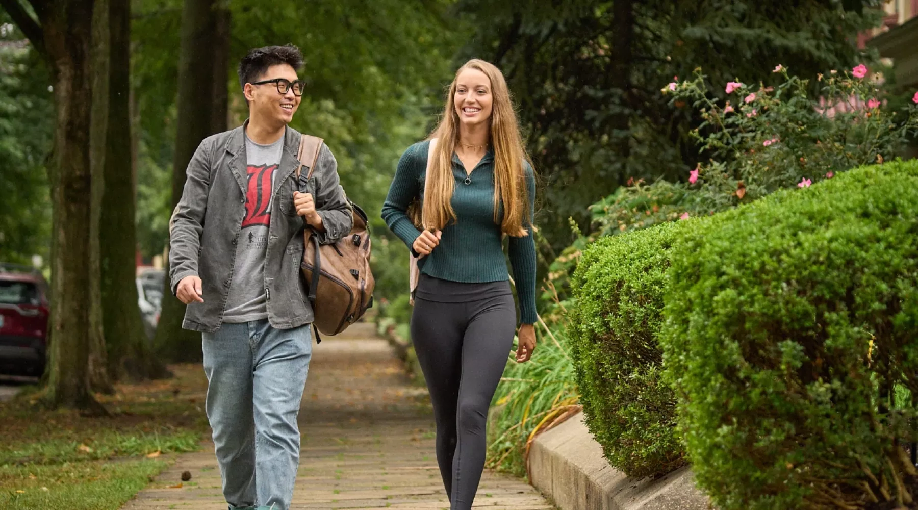 Two students walking in Old Louisville neighborhood, talking.