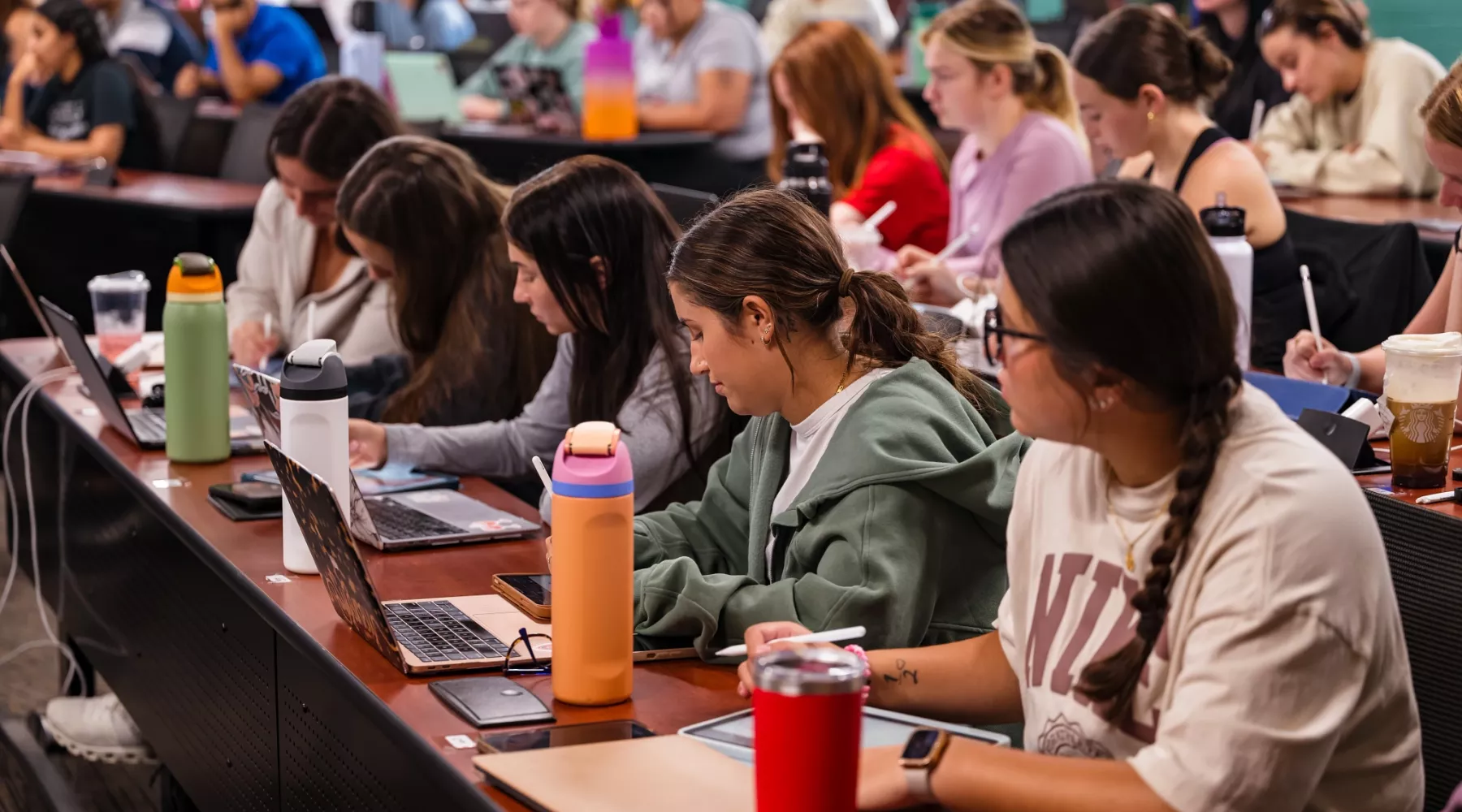 Students in a nursing lecture listening and taking notes.