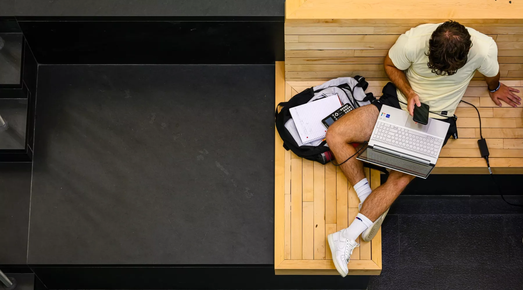 Overhead shot of a student studying on the steps inside the Belknap Academic Building