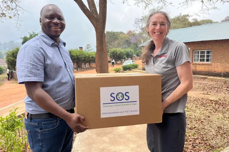 Man and woman holding a box of medical and research supplies in Malawi