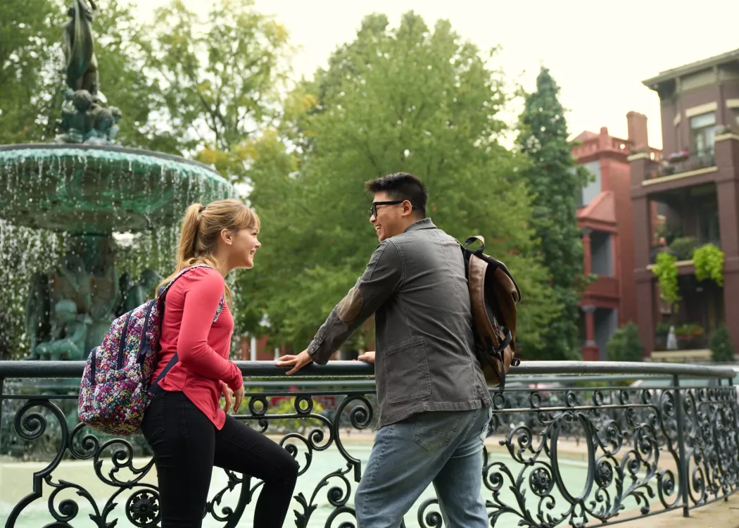 Two students talking beside the fountain in Old Louisville's St. James Court.