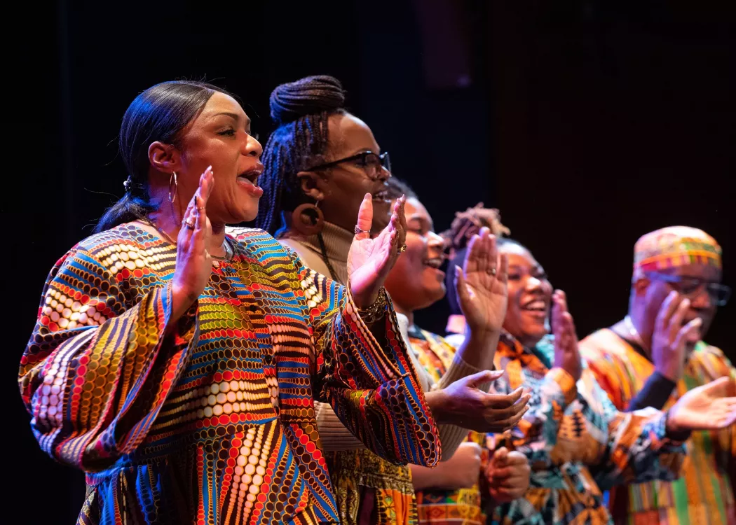 A group of performers on stage in brightly colored attire