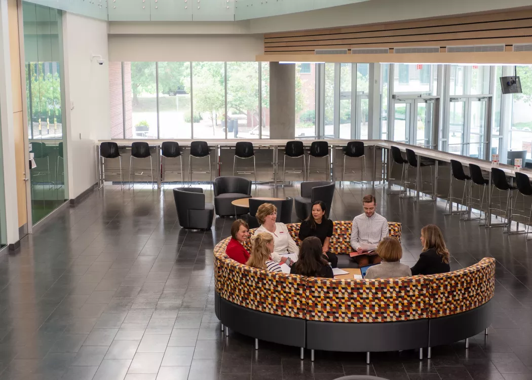 Group of employees having a conversation in a meeting while seated in the Belknap Academic Building