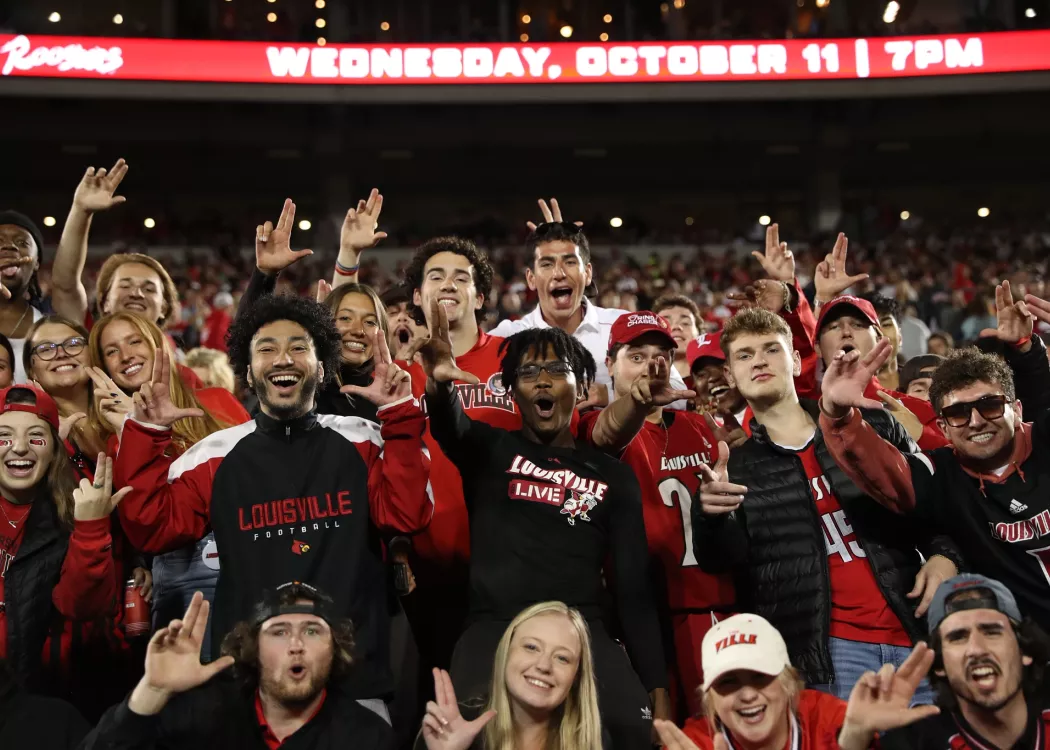 Fans cheering and throwing up their L's at the Notre Dame vs UofL football game at Cardinal Stadium.