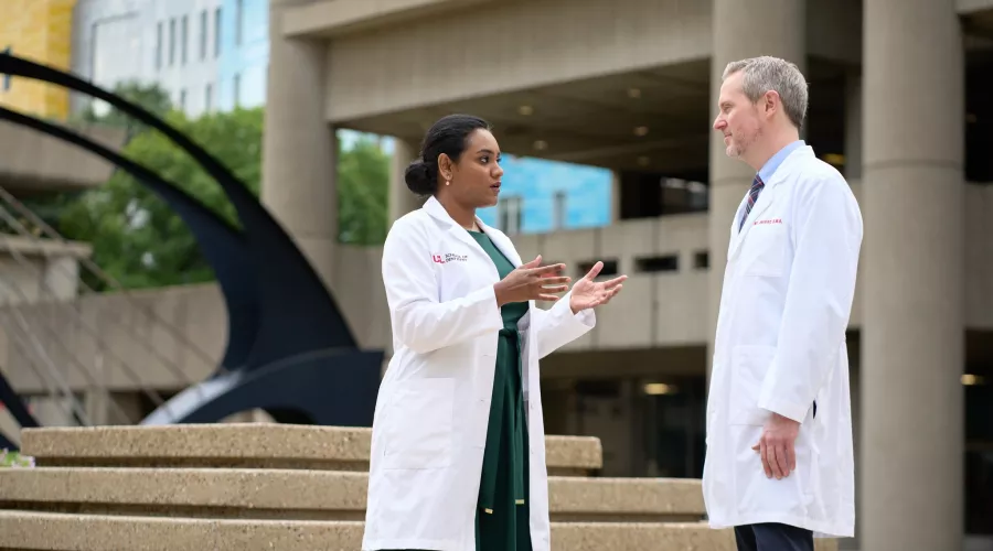 Female and male doctor having a conversation on HSC campus.